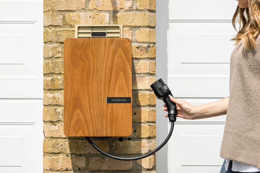 Wooden EV home charger installed on a brick wall for sustainable transportation.
